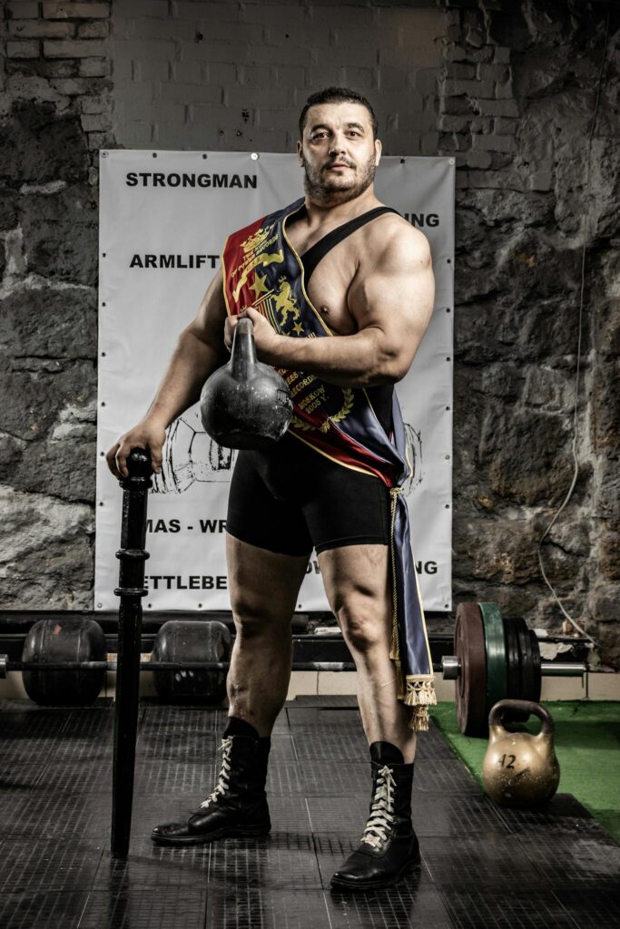 Muscular athlete posing confidently with kettlebell, symbolizing strength and athleticism.